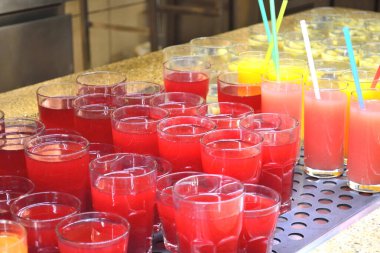 Yaban mersinli, greyfurtlu ve elmalı meyveli içecekler bir kafede rafta.