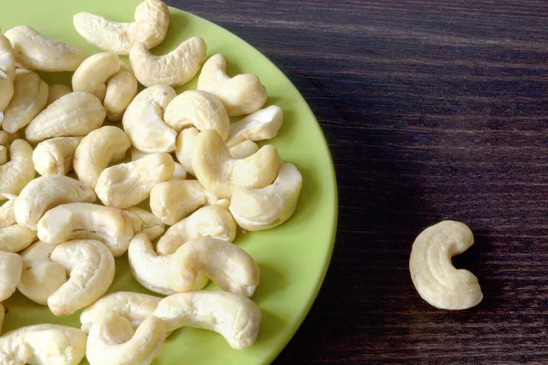 Cashew Nuts Poured Green Plate Dark Table — Stock Photo, Image