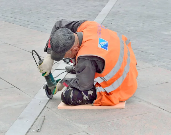 Een Arbeider Uniform Brengt Naad Van Aangelegde Plavuizen Één Lijn — Stockfoto