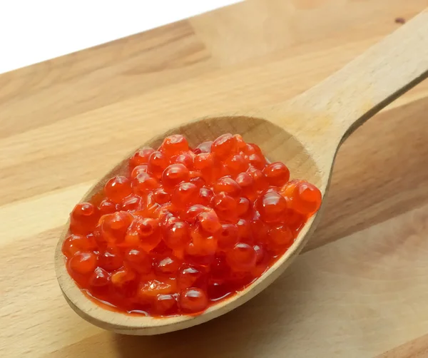 Red caviar in a wooden spoon — Stock Photo, Image