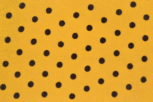 Fabric dyed in black peas on a yellow background — Stock Photo, Image