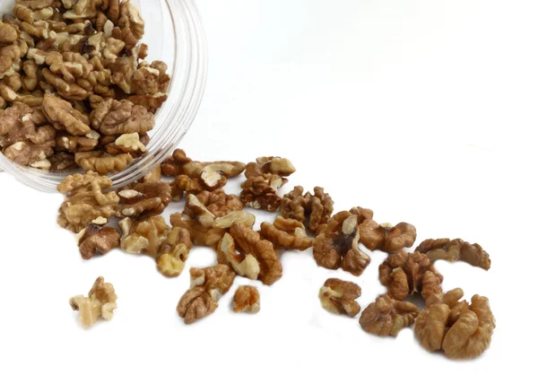 Walnuts spill out of the plastic container — Stock Photo, Image