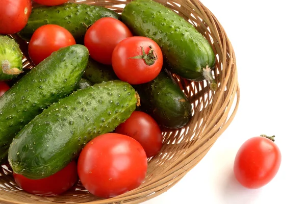 Cucumbers and tomatoes in a wicker basket — Stock Photo, Image