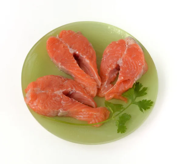 Three salmon steaks are  on a plate — Stock Photo, Image