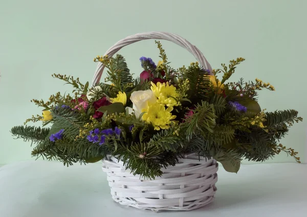 Bouquet of flowers in a wicker basket — Stock Photo, Image