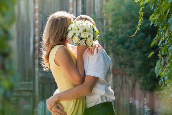 Das Paar küsst sich hinter einem Strauß Rosen — Stockfoto