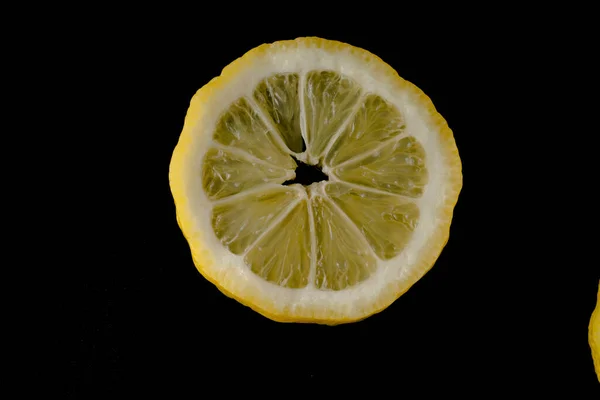 Cinque fette di limone allineate a semicerchio su fondo nero isolate — Foto Stock