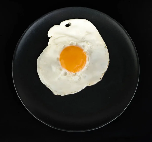 Fried Egg Lies Black Plate Black Background Isolated — Stock Photo, Image