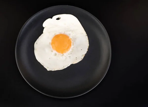 Fried Egg Lies Black Plate Black Background Isolated — Stock Photo, Image