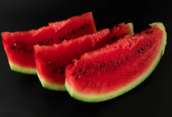 Three skibki ripe watermelon on a black background — Stock Photo, Image