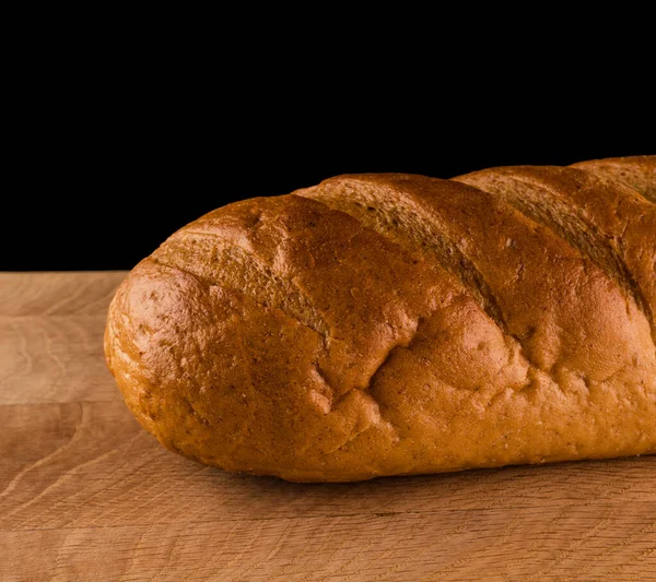 Parte Una Pagnotta Pane Primo Piano Asse Legno Uno Sfondo — Foto Stock