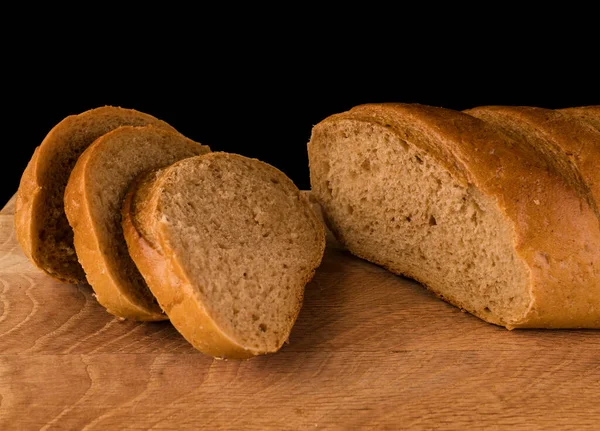 Část Bochníku Chleba Plátků Něj Položené Dřevěné Desce Černém Pozadí — Stock fotografie
