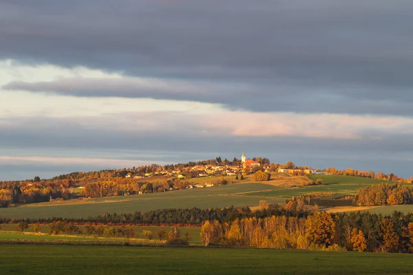 Осенний пейзаж с деревней на холме — стоковое фото