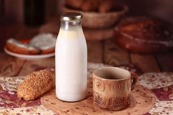 Gliniany kubek i butelka mleka, croissant pełnoziarnisty — Zdjęcie stockowe