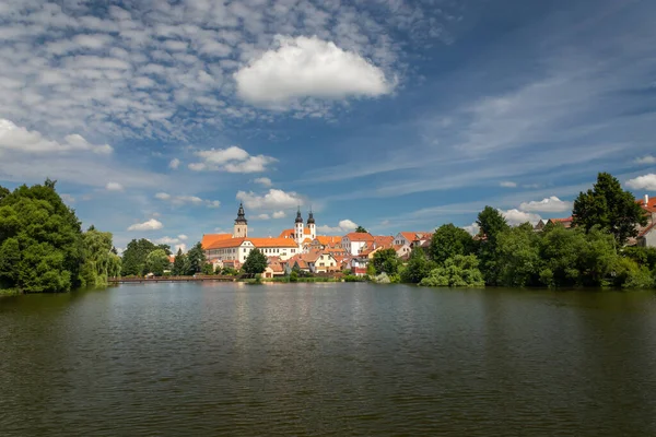 Telc paisaje urbano en la República Checa, en el fondo Iglesia del Nombre de Jesús, en el estanque de primer plano Ulicky — Foto de Stock