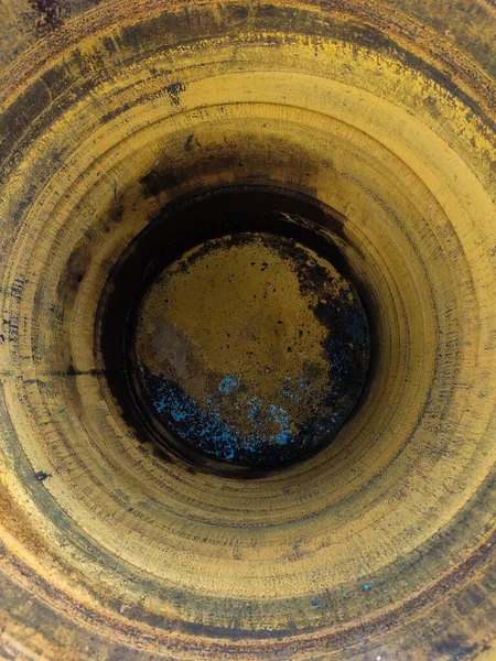 The bottom of an old rusty iron barrel close up