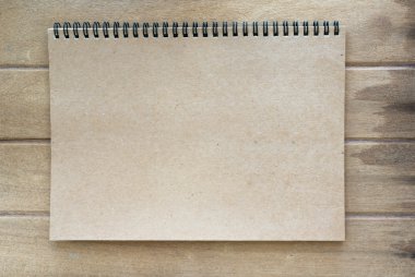 Ahşap arka plan üstünde kahverengi renk defter