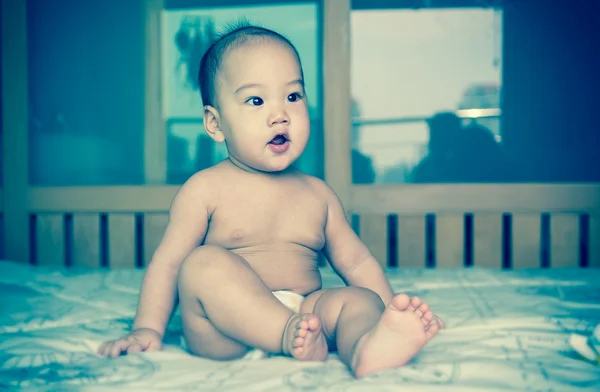 Portret van gelukkig Aziatische baby op het bed — Stockfoto