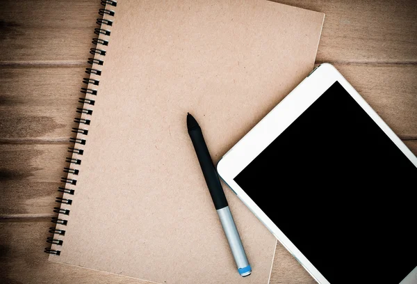 Notebook s tabletu a pera na dřevěný stůl — Stock fotografie