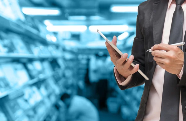 Uomo d'affari che utilizza il tablet su Abstract foto offuscata della libreria con persone sfondo, tono di colore blu — Foto Stock