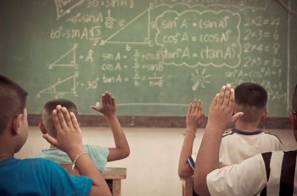 Levantar las manos en el aula en el campo Escuela entre compañeros de clase — Foto de Stock