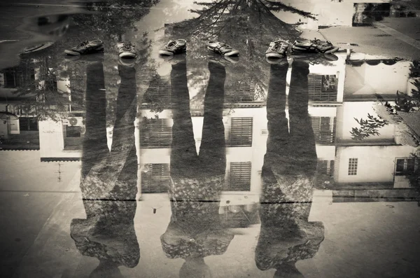 Три человека отражение в воде после дождя, двойное воздействие тени — стоковое фото