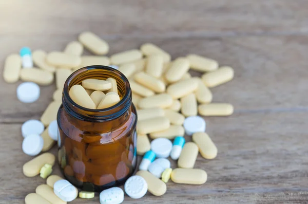 Comprimidos ou vitamina em garrafas de medicina em fundo de madeira — Fotografia de Stock