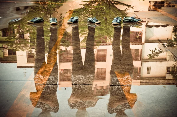 Три человека отражение в воде после дождя, двойное воздействие тени — стоковое фото