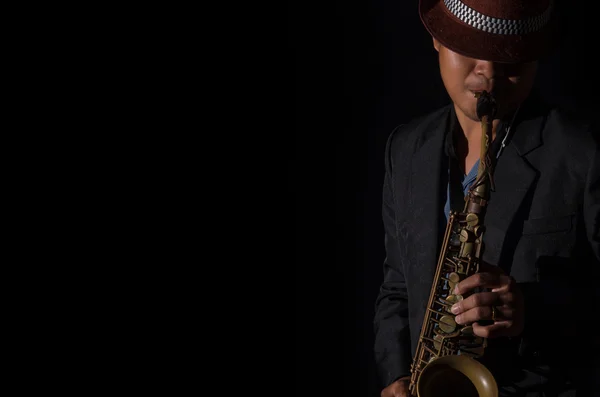 A saxophone player in a dark background — Stock Photo, Image