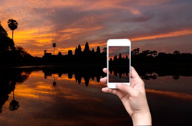 Siem Reap resimler siluet Angkor Wat gündoğumu alarak mobil akıllı telefon tutan eller. Kamboçya