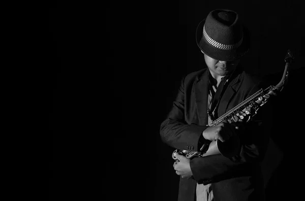 Un saxofonista en un fondo oscuro, tono blanco y negro —  Fotos de Stock