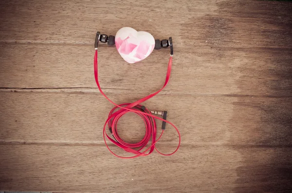 Auriculares de audio portátiles con jabón para el corazón sobre fondo de madera — Foto de Stock