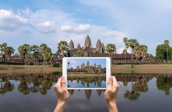 Mãos femininas segurando tablet tirando fotos Angkor Wat em Siem Reap. Camboja — Fotografia de Stock
