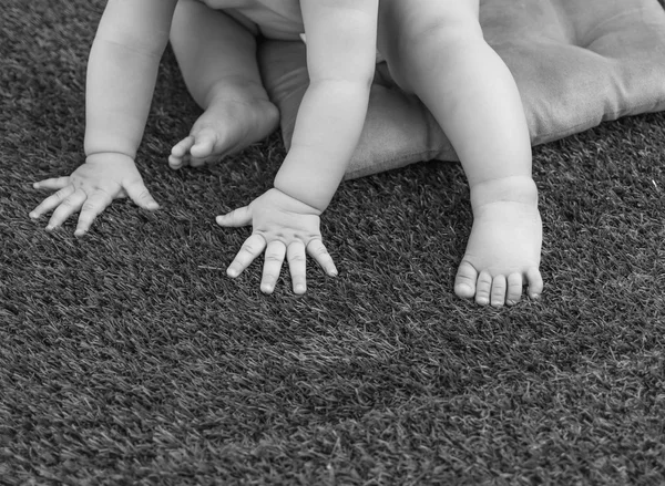 Mãos e pés de bebê na grama — Fotografia de Stock