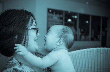 Anne ile mutlu Asya bebek