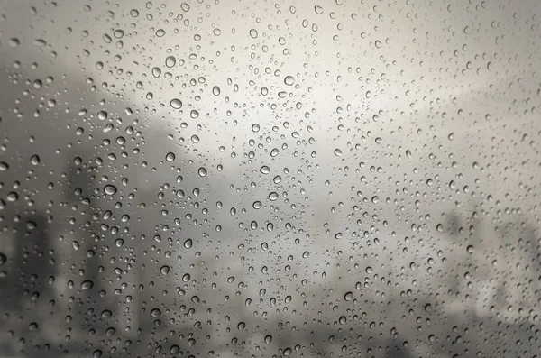Kapky vody na skleněné okno s panoráma — Stock fotografie