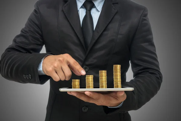 Affärsman med tablett med gyllene mynt — Stockfoto