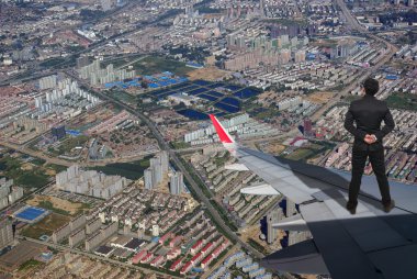 Uçak kanadı üzerinde duran işadamı 