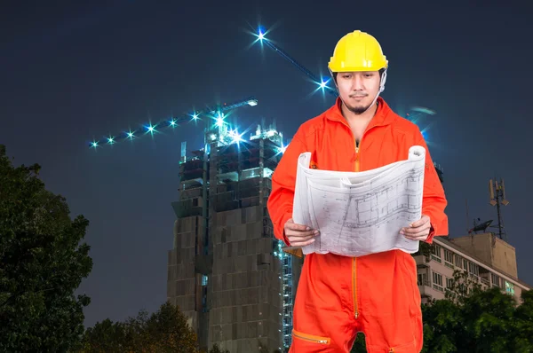 Asian engineer looking at blueprint — Stock Photo, Image