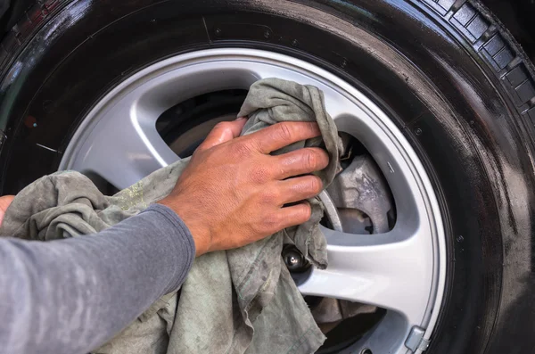 Працівник миє колесо автомобіля — стокове фото