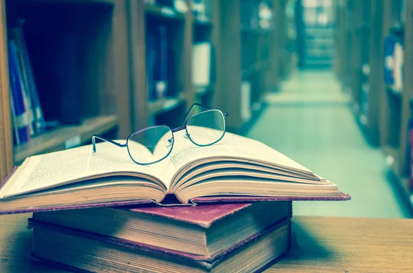 Glasses on books in library — Stock Photo, Image