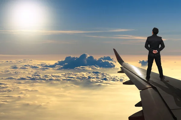 Biznesmen, stojąc na skrzydle samolotu — Zdjęcie stockowe
