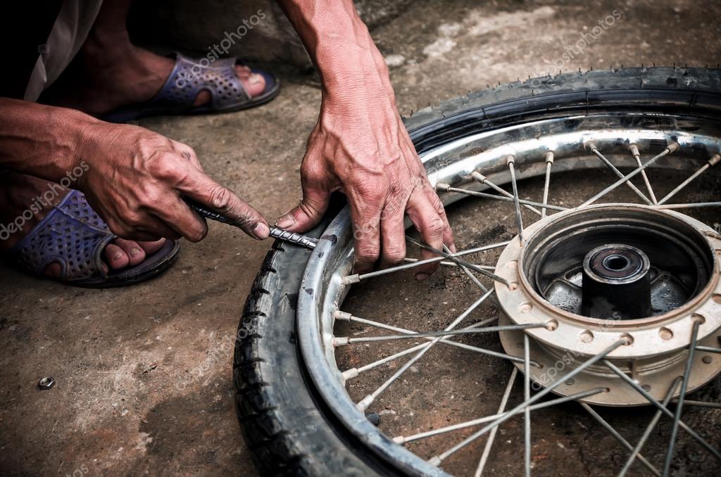 Mechanic changing motorcycle tire Stock Photo by ©Tzido 118287452