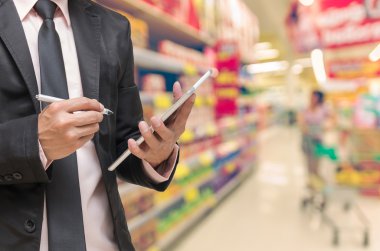 İşadamı Süpermarket'te not defteri yazıyor 