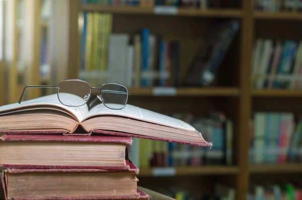 Glasses on books in library — Stock Photo, Image