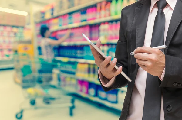 Businessman writing notebook on Supermarket — Stock Photo, Image