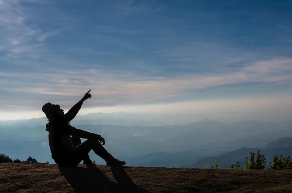 Silhouette of man pointing over mountains — Stock Photo, Image