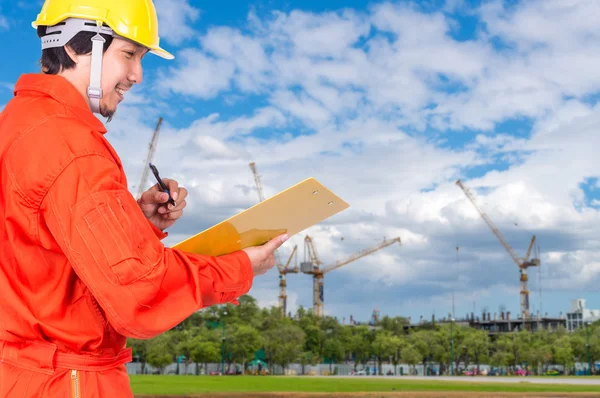 Asian engineer writing note pad on Under construction — Stock Photo, Image