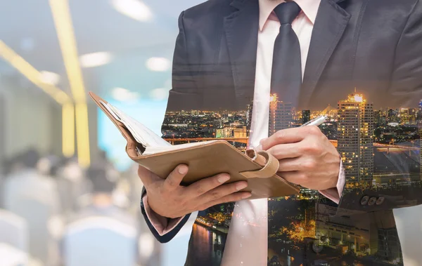 Businessman writing in notebook