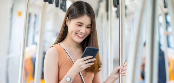 Joven Pasajera Asiática Usando Teléfono Móvil Inteligente Mirando Hacia Fuera —  Fotos de Stock